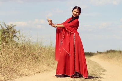 Frau in einem roten Gewand tanzt in der Natur